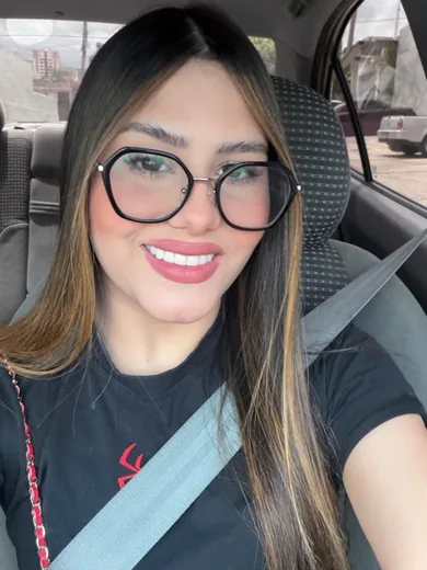 Woman in glasses smiling in a car